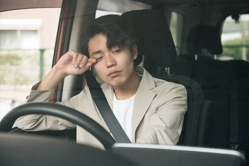 眠そうにする運転手