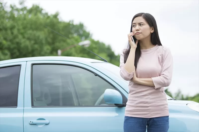 車を降りて電話する女性